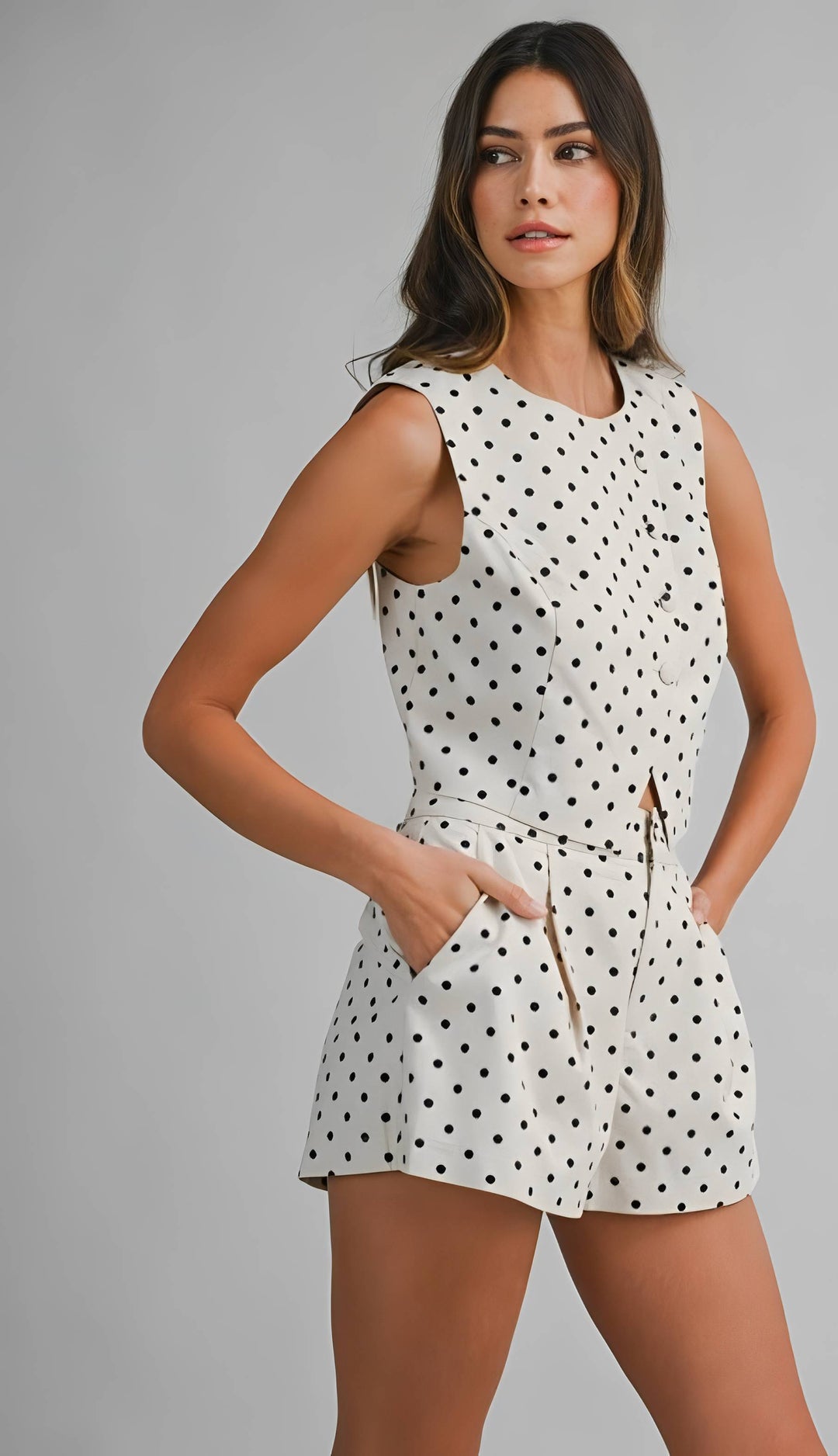 Woman wearing a polka dot dress against a gray background