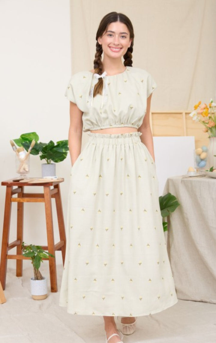 Woman wearing a light green skirt set  with a white background