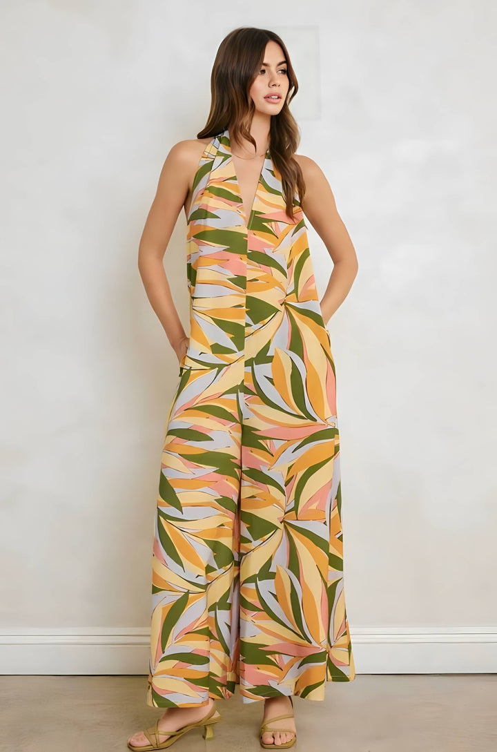 Woman wearing a colorful leaf-patterned jumpsuit against a plain background