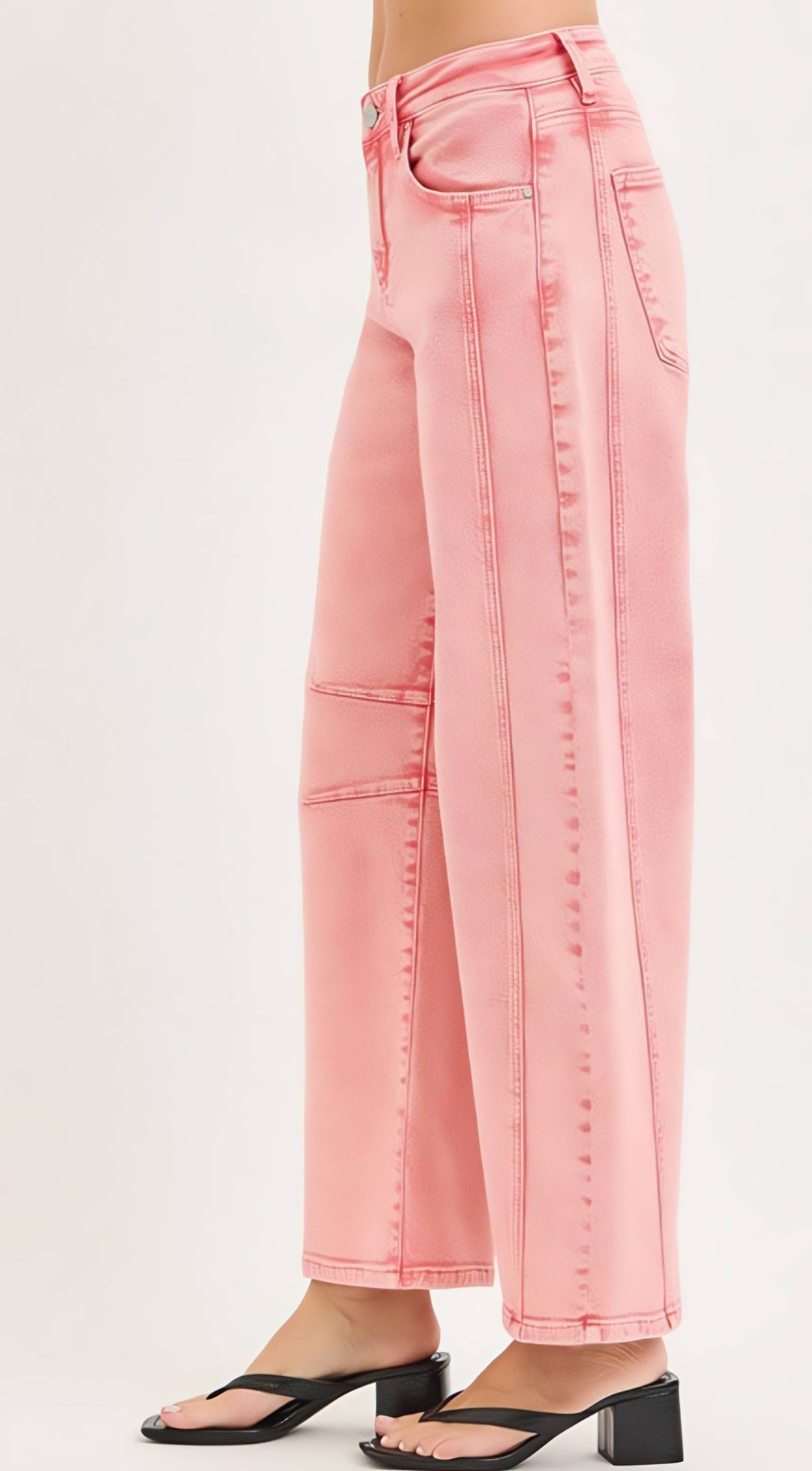 Pink jeans worn by a person on a white background