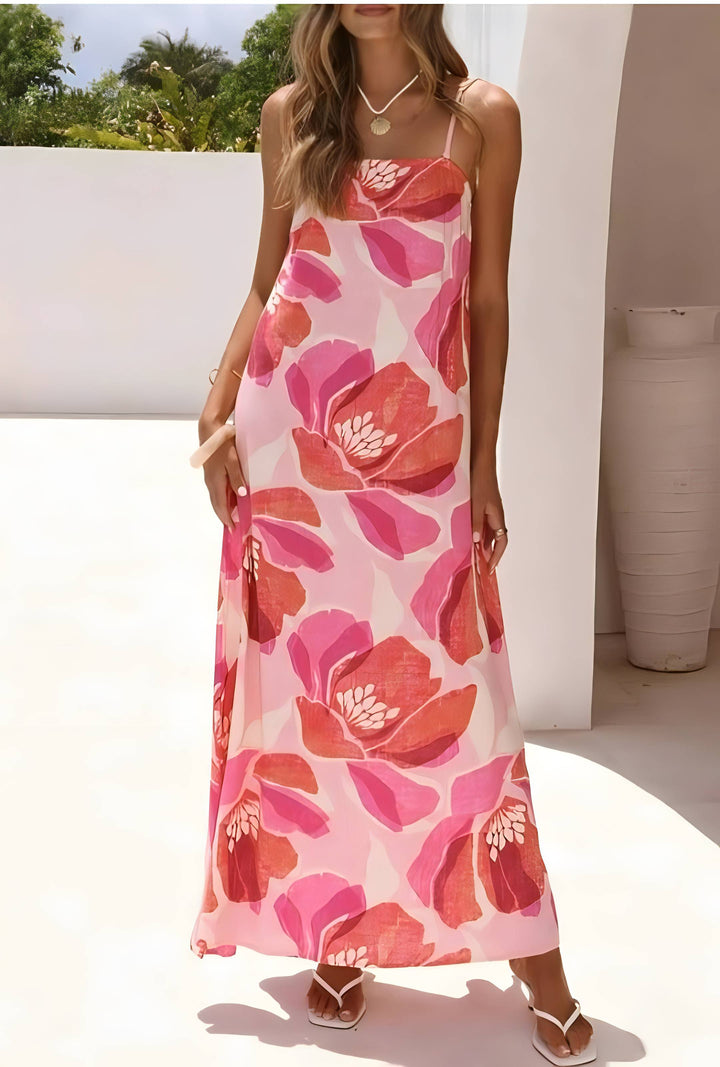 Woman wearing a pink floral dress standing outdoors.