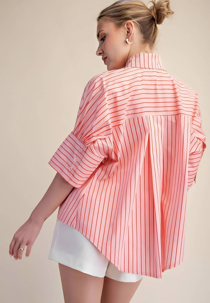 Woman wearing a pink and white striped shirt with a beige background