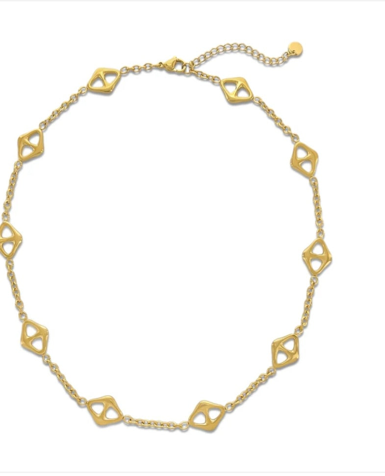 Gold necklace with geometric links on a white background