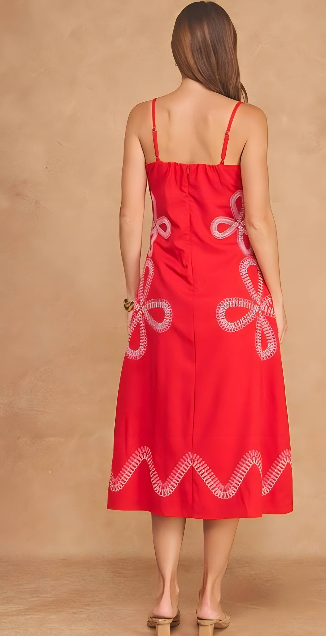 Red dress with white lace details on a beige background