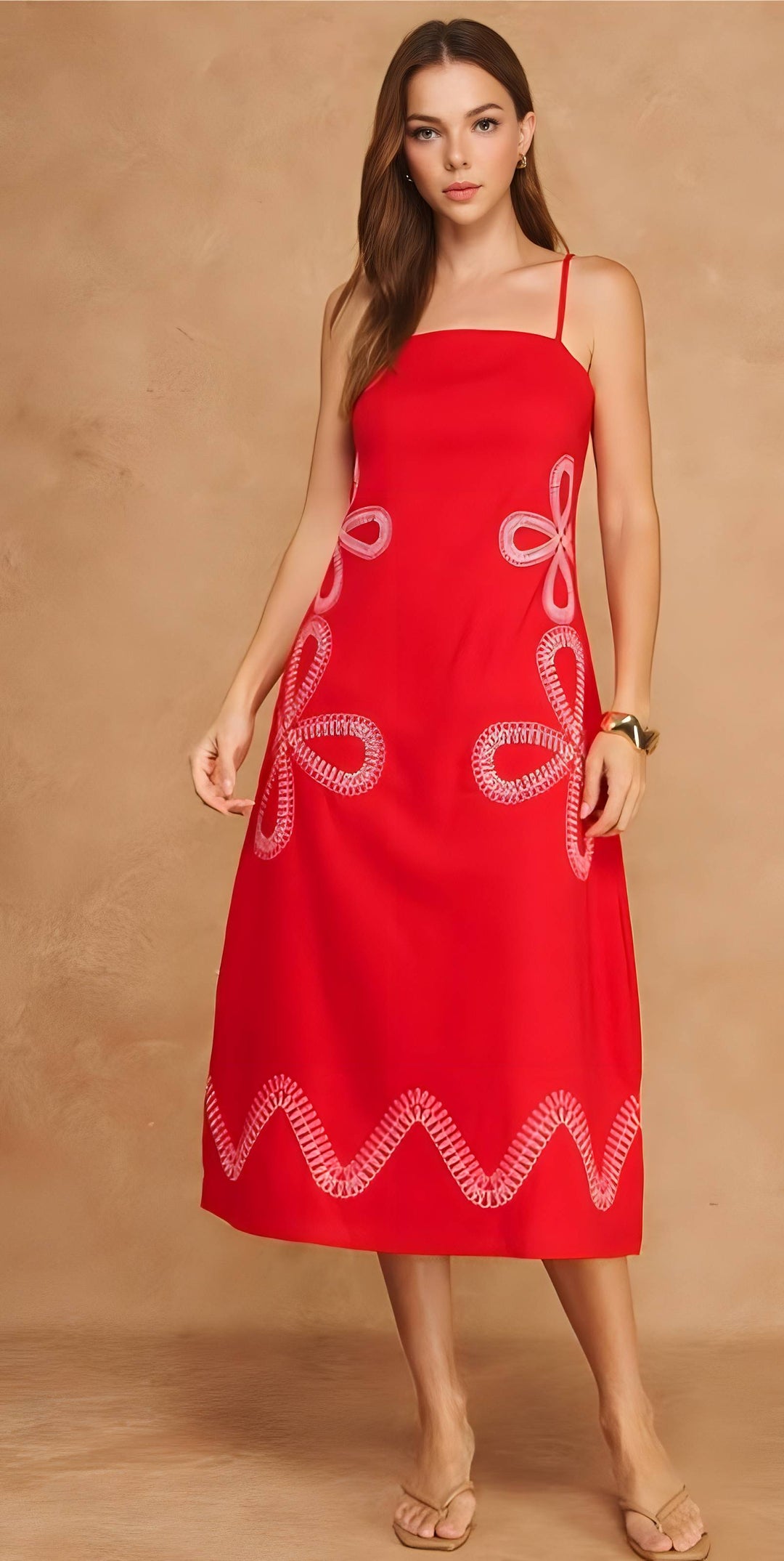 Woman wearing a red dress with white patterns on a beige background