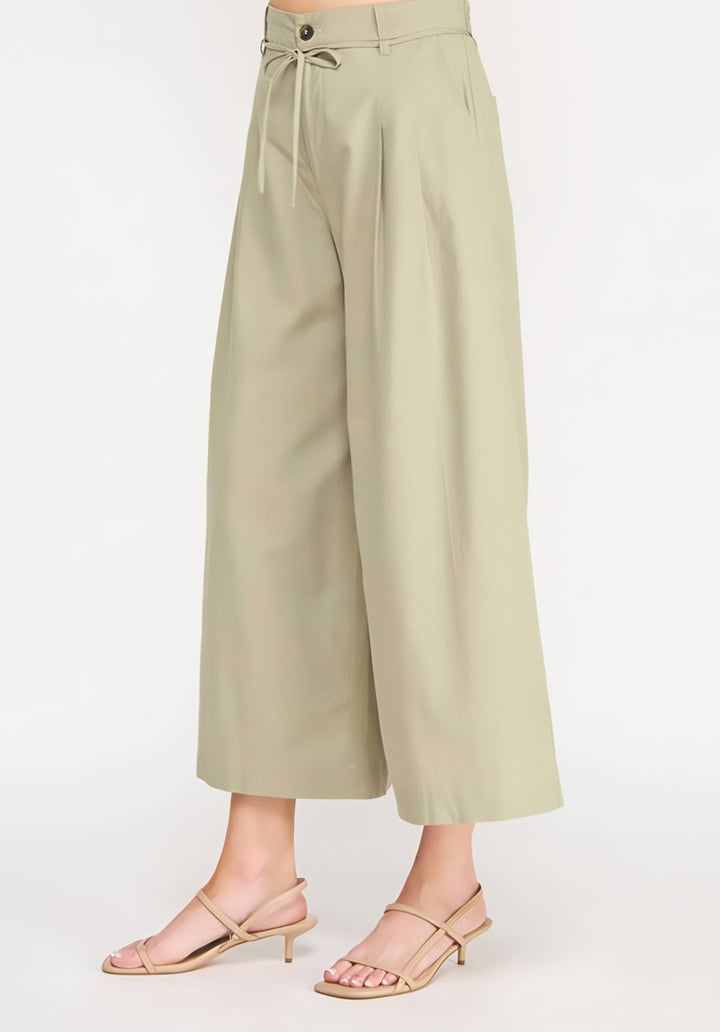Light green wide-leg pants worn by a person on a white background