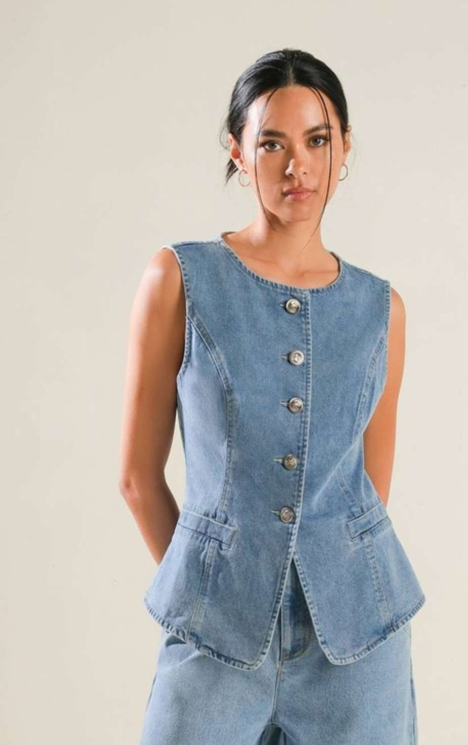Trendy denim vest featuring a classic button-down front and stylish pocket details. Perfect for casual, laid-back outfits, this versatile vest adds a touch of rugged fashion to any wardrobe. Available in various washes and distressed styles for a timeless look.