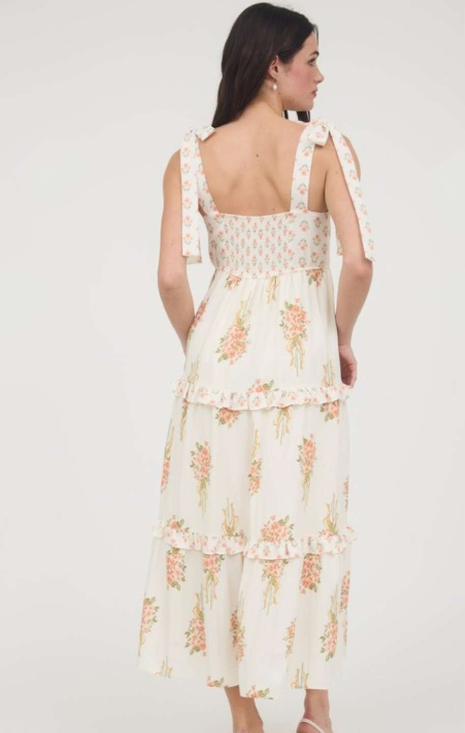 Soft peach dress with vibrant floral bouquet print, feminine sleeveless design for spring and summer wear
