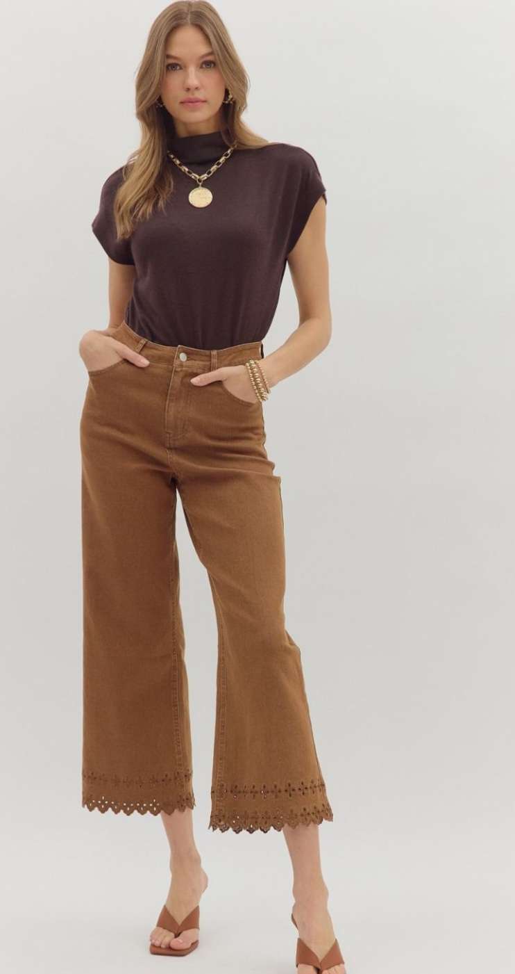 High-waisted brown denim pants featuring decorative eyelet hem