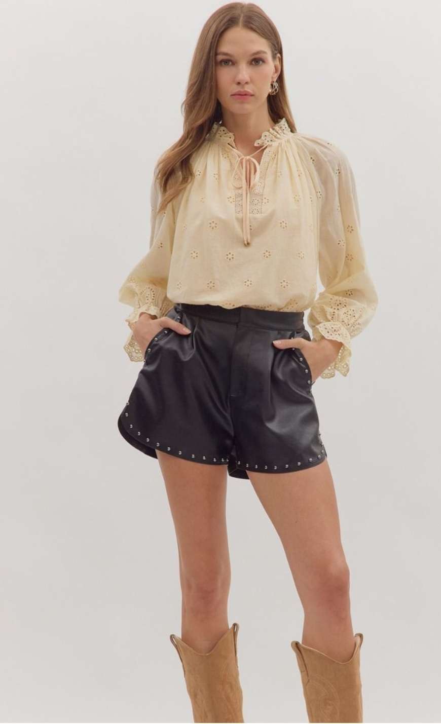 Women's black studded faux leather shorts with high-waisted fit and edgy punk-rock style