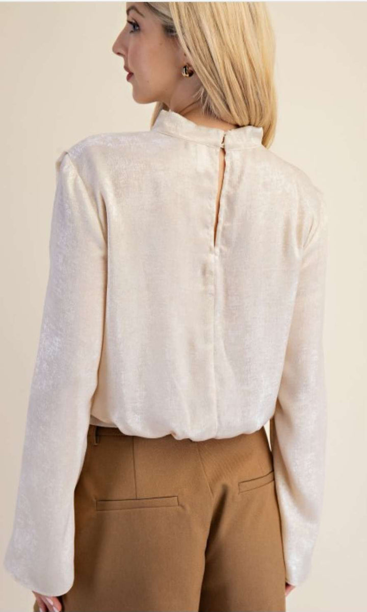 Chic cream high neck blouse featuring long sleeves and a minimalist design