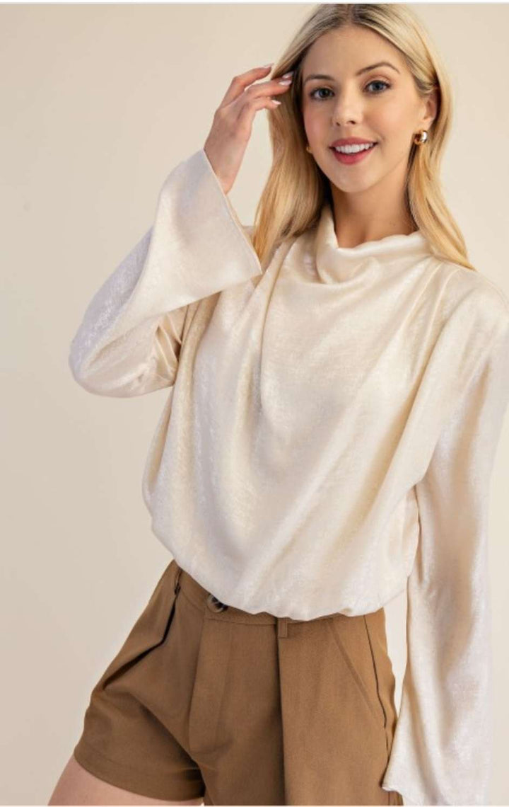 Chic cream high neck blouse featuring long sleeves and a minimalist design