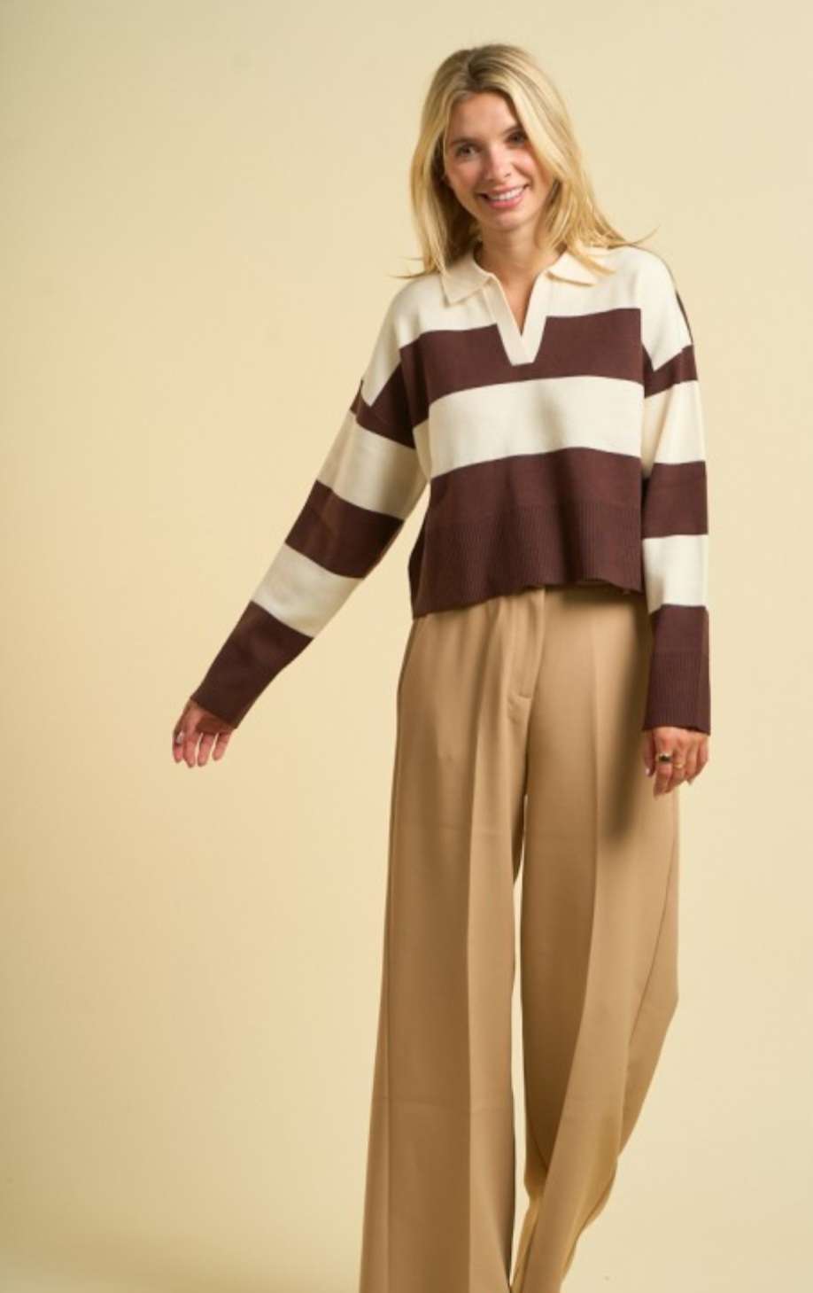 Women’s brown stripe sweater polo with classic collar, long sleeves, and ribbed cuffs, styled for a chic smart-casual look.