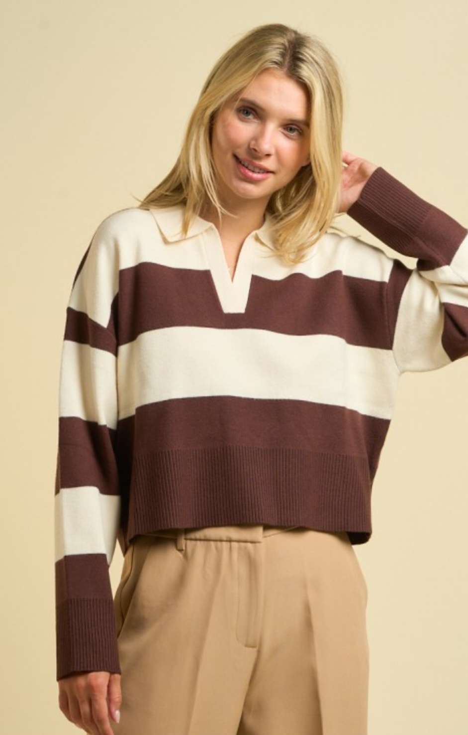 Women’s brown stripe sweater polo with classic collar, long sleeves, and ribbed cuffs, styled for a chic smart-casual look.