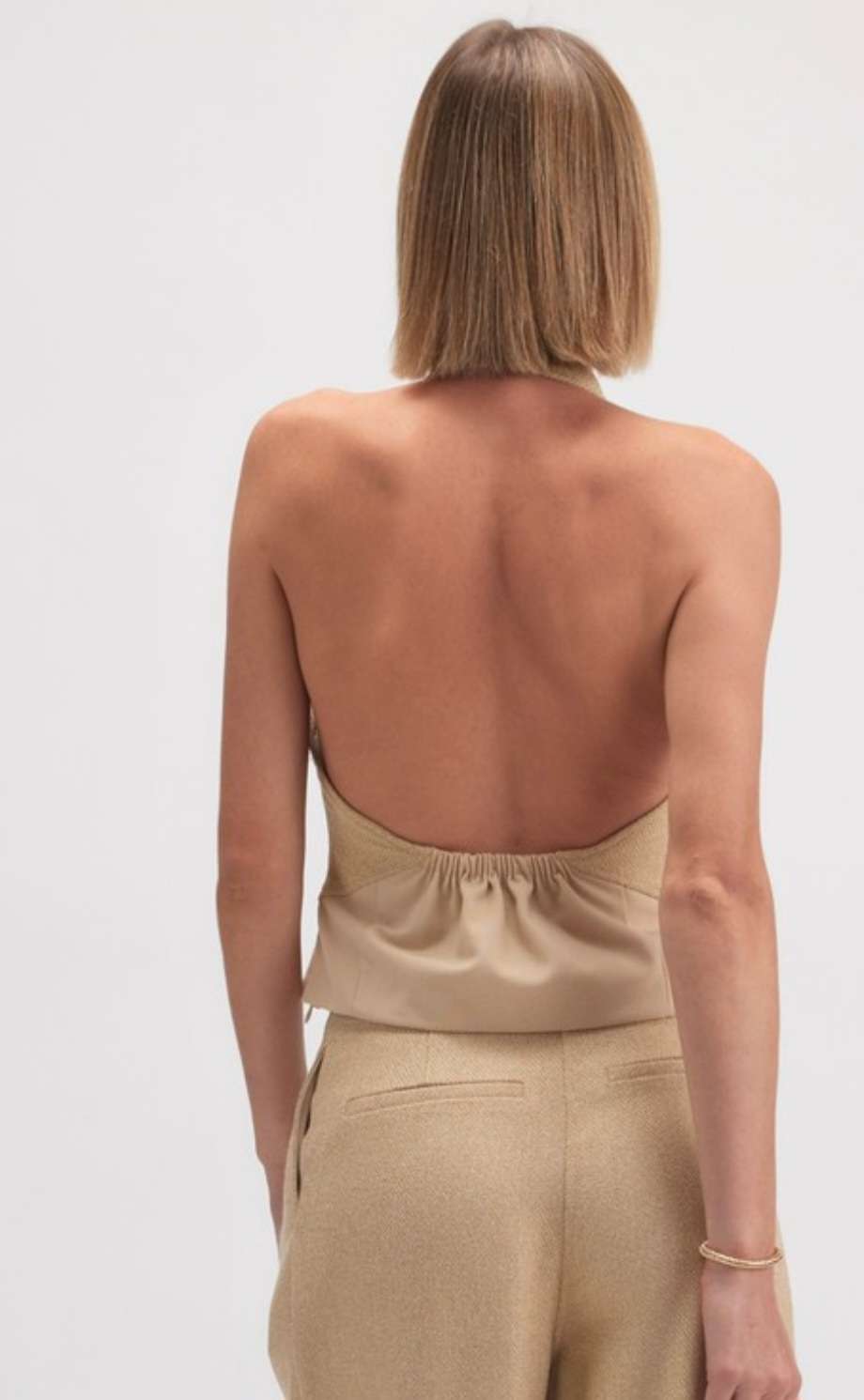Women's beige halter neck tank with open back and minimalist design, perfect for casual or dressy outfits