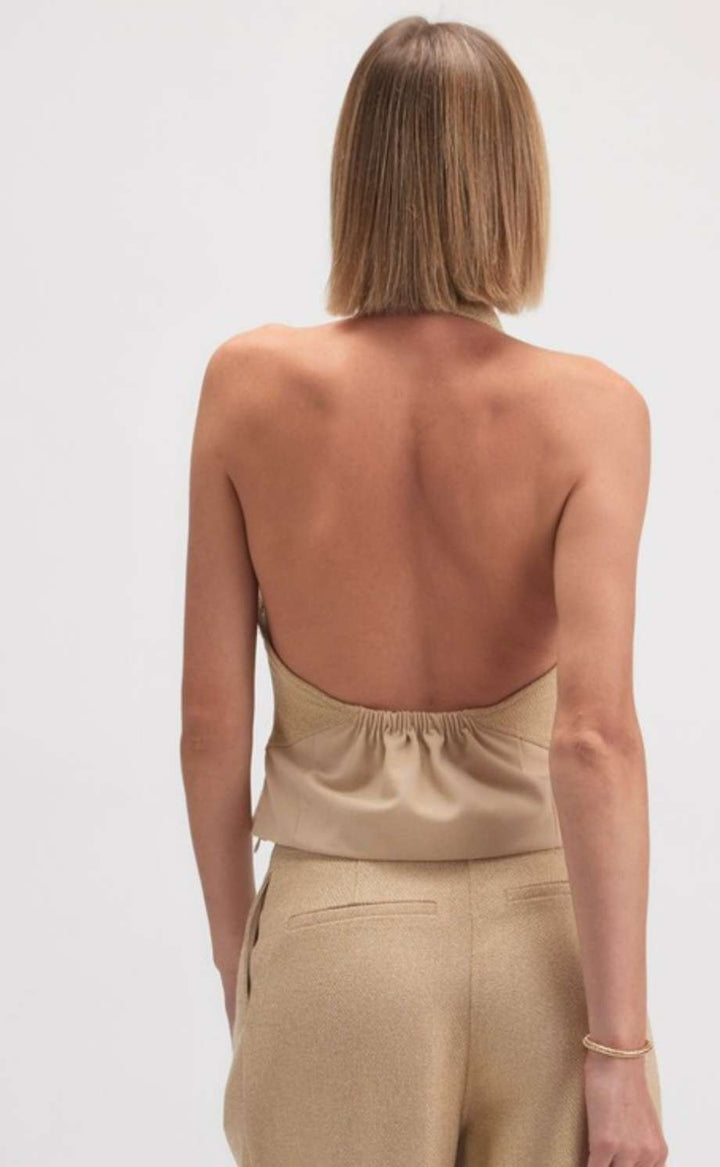 Women's beige halter neck tank with open back and minimalist design, perfect for casual or dressy outfits