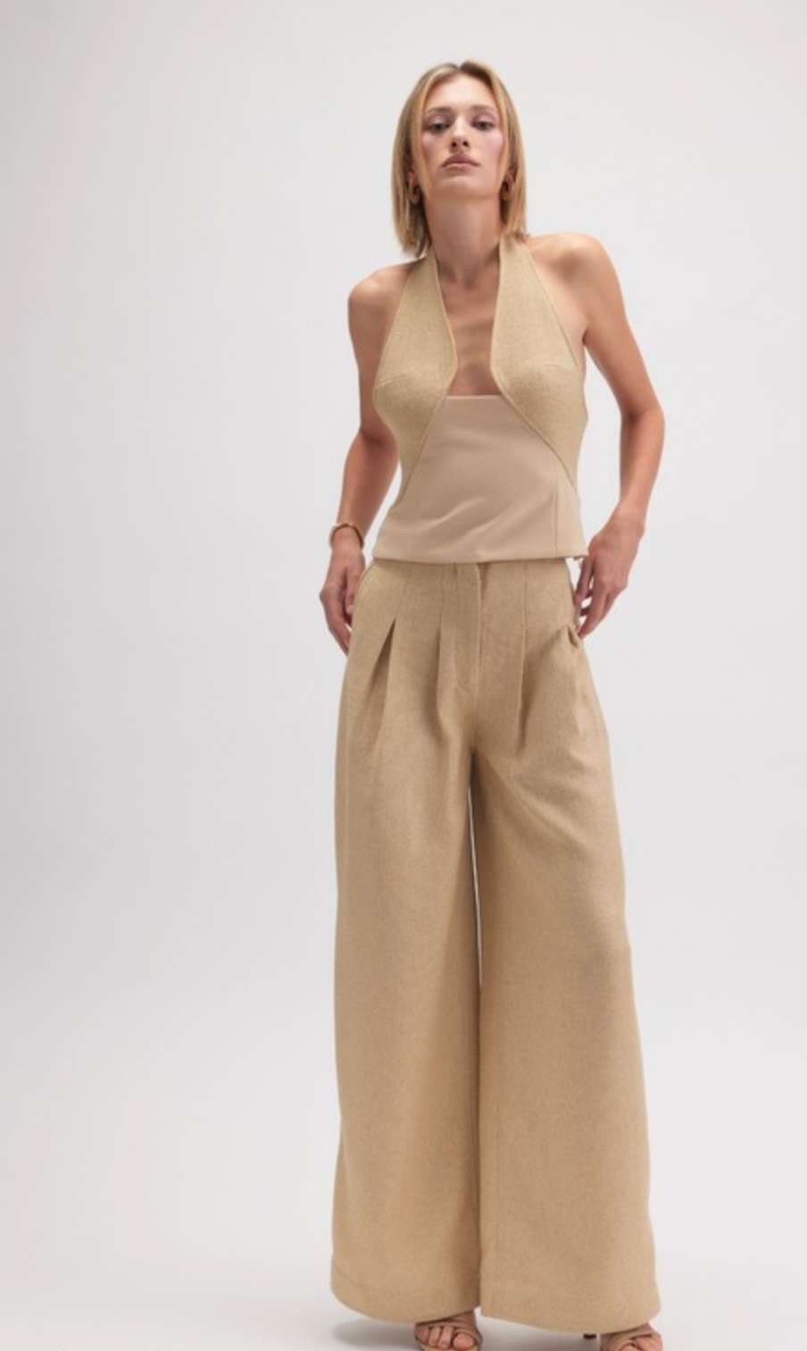 Women's beige halter neck tank with open back and minimalist design, perfect for casual or dressy outfits