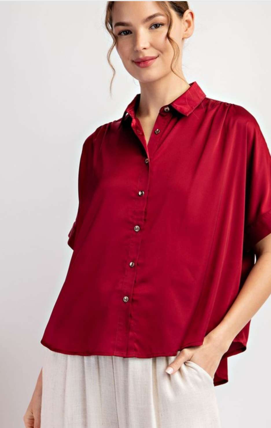 Women’s wine satin button short sleeve blouse with a smooth, silky finish.