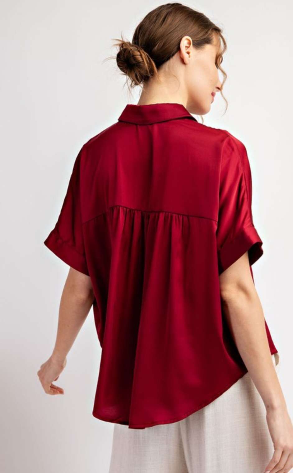 Women’s wine satin button short sleeve blouse with a smooth, silky finish.