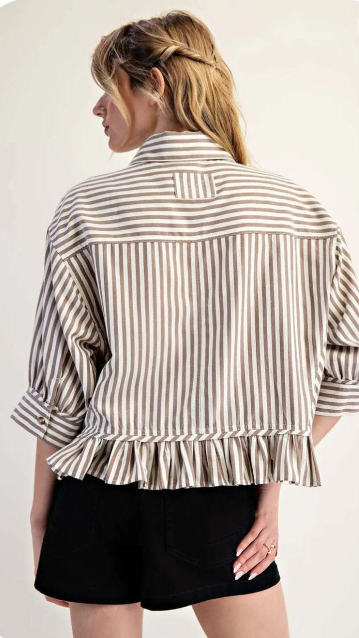 Stylish beige stripe top with ruffle hem paired with jeans for a modern, feminine look.