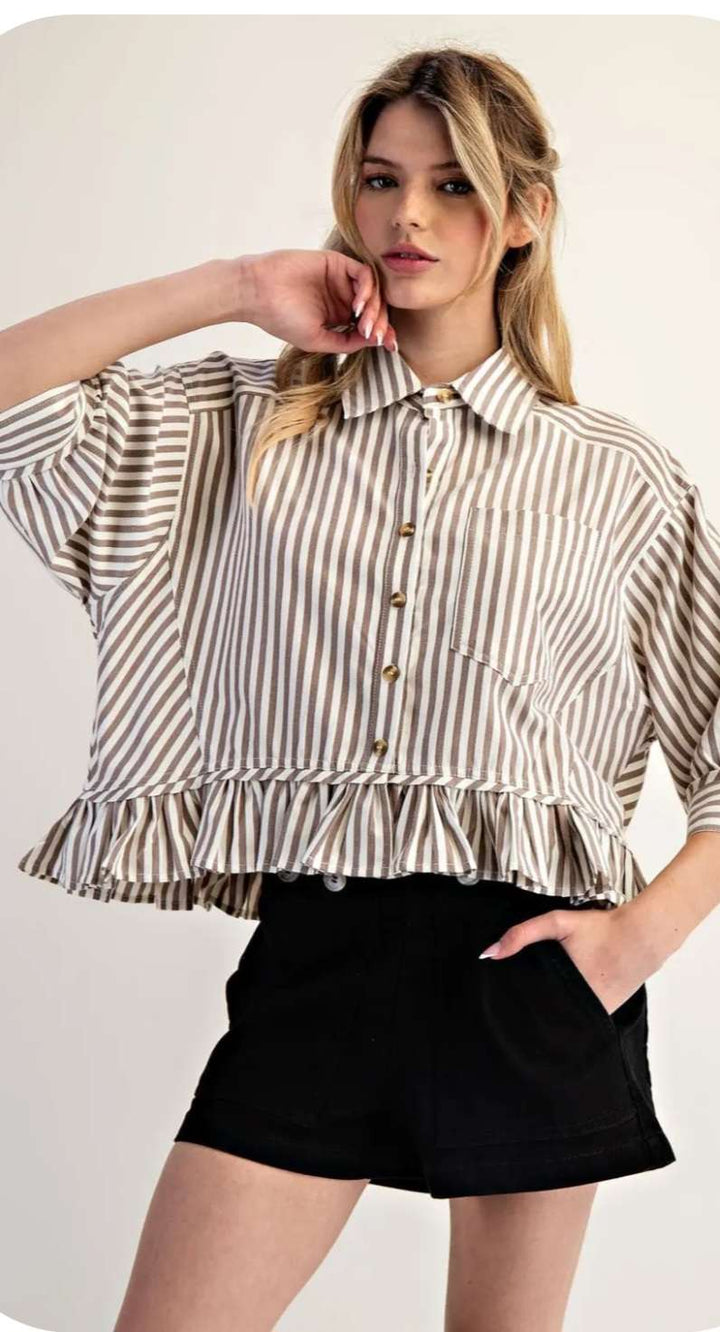 Stylish beige stripe top with ruffle hem paired with jeans for a modern, feminine look.