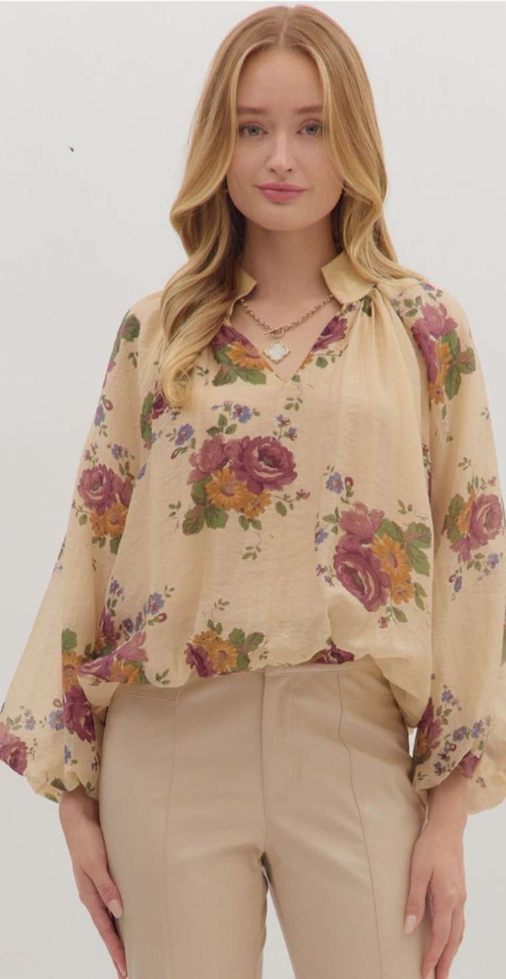 Women’s floral print puff sleeve top with V-neckline and bubble hem in lightweight fabric.