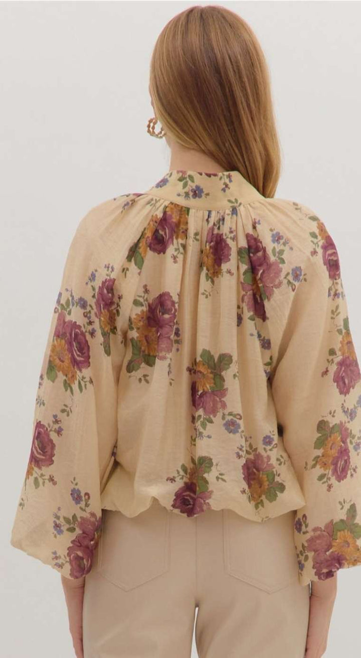 Women’s floral print puff sleeve top with V-neckline and bubble hem in lightweight fabric.
