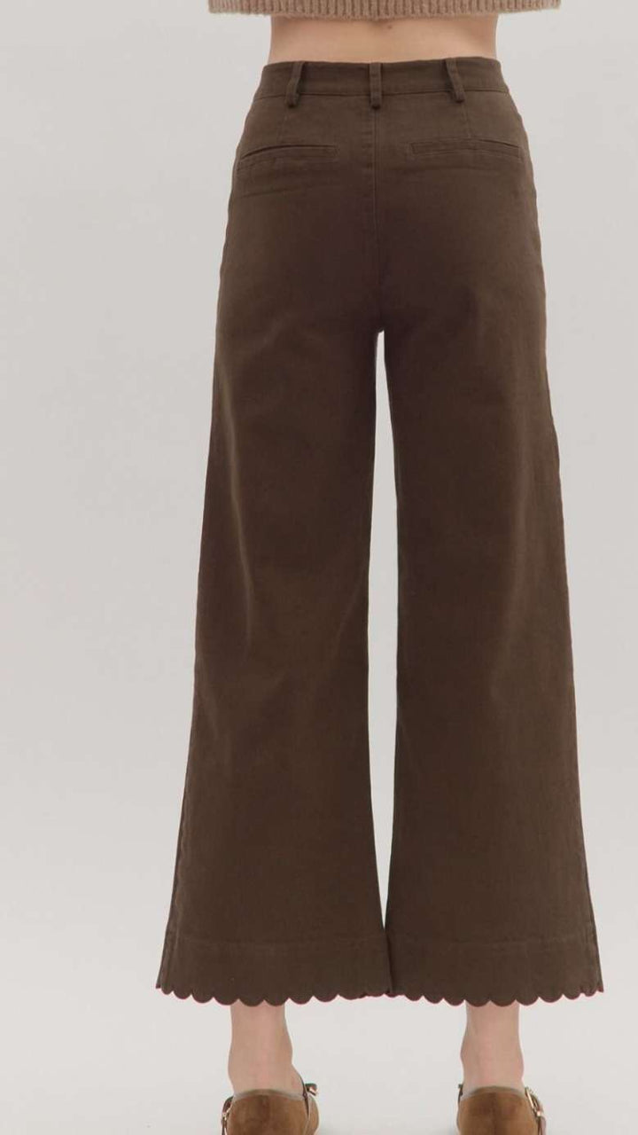 Women’s brown jeans with scallop trim hem and front pockets, high-waisted relaxed fit.