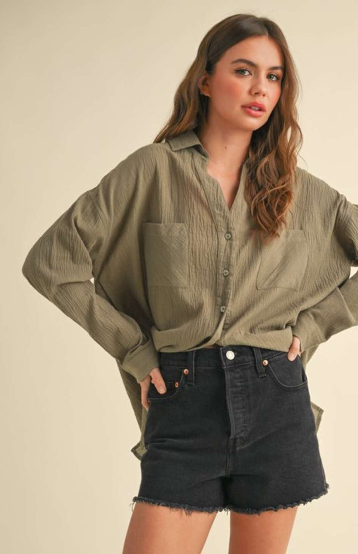 Olive green button-up top with classic collar and versatile long sleeves for everyday wear.