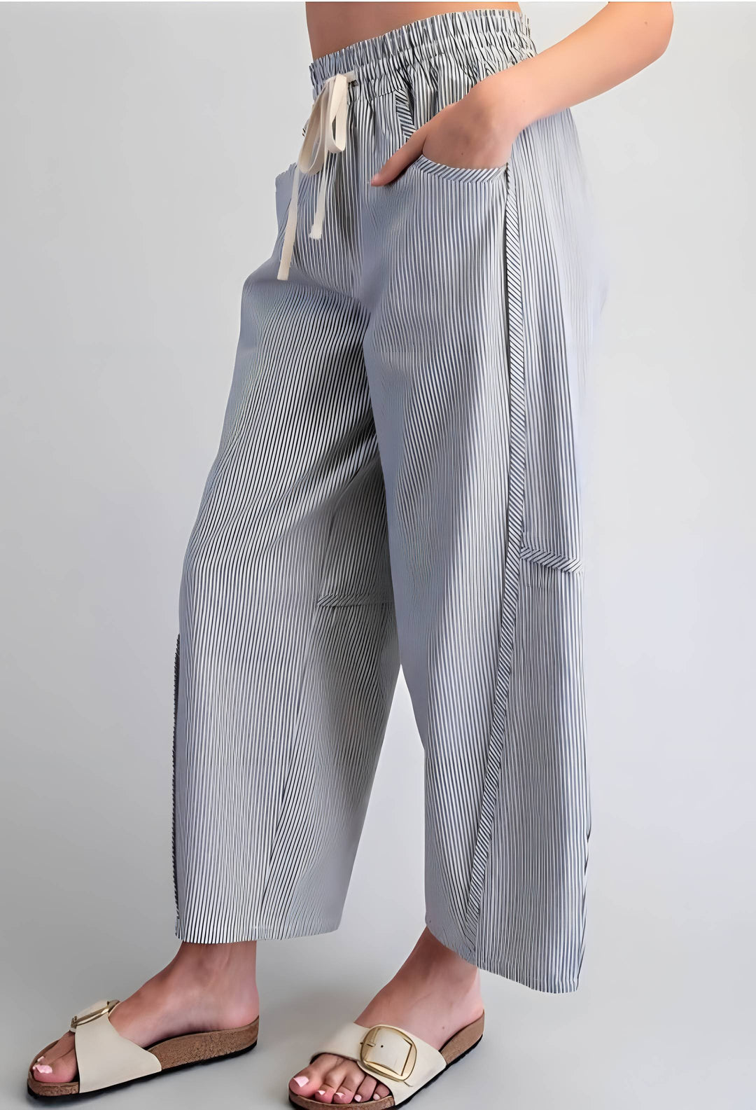 Person wearing blue and white striped pants on a plain background