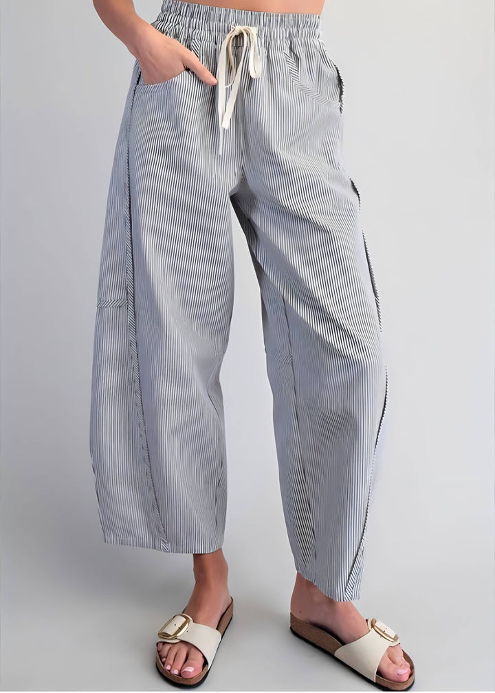 Person wearing blue and white striped pants on a plain background