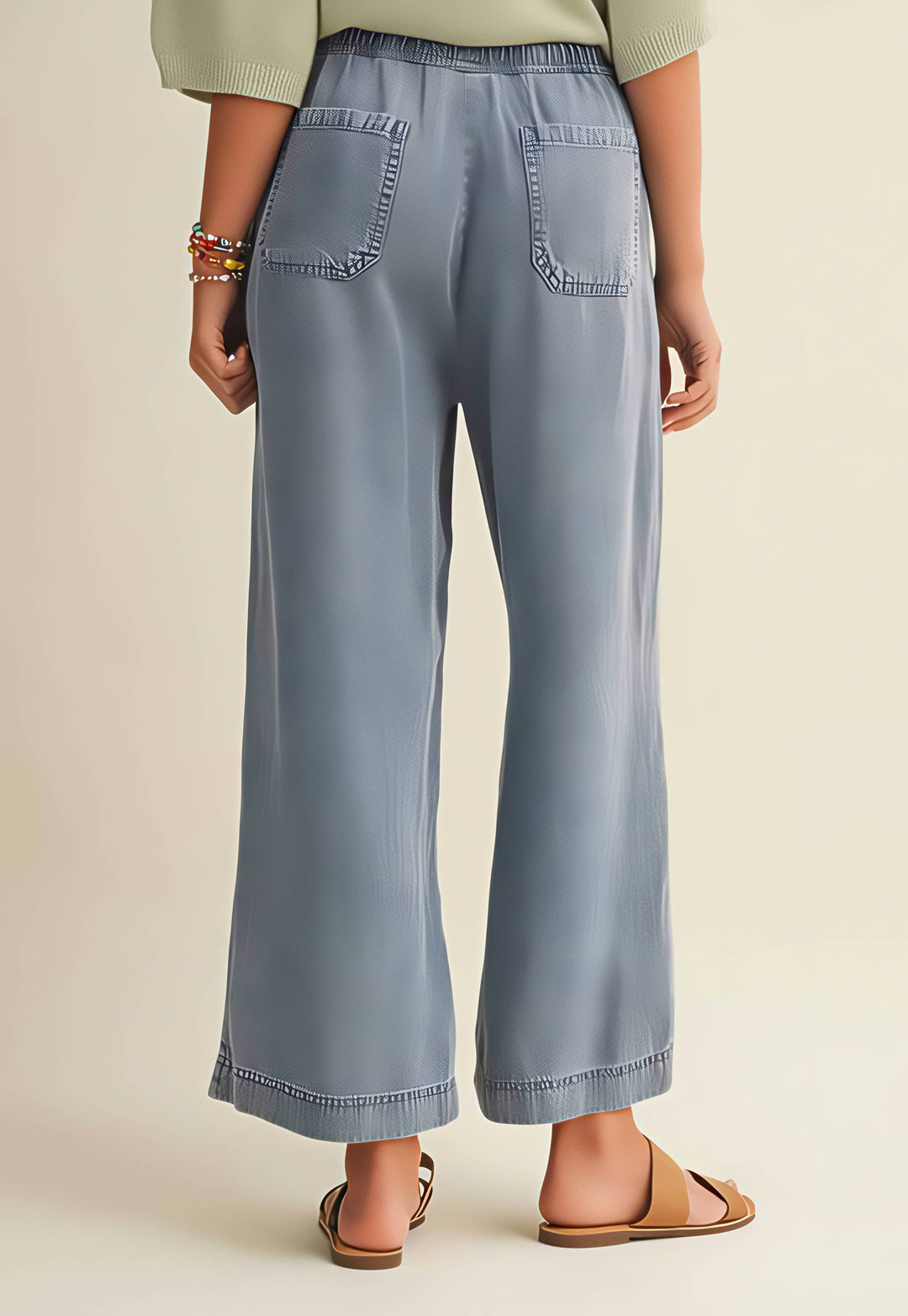 Light blue wide-leg jeans worn by a person on a beige background