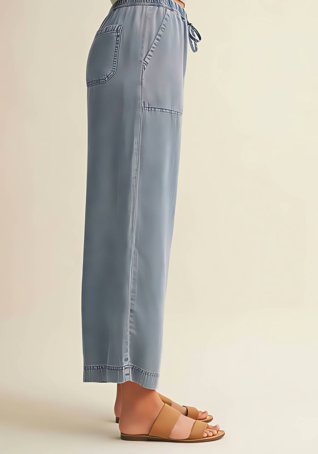 Light blue pants worn by a person on a beige background