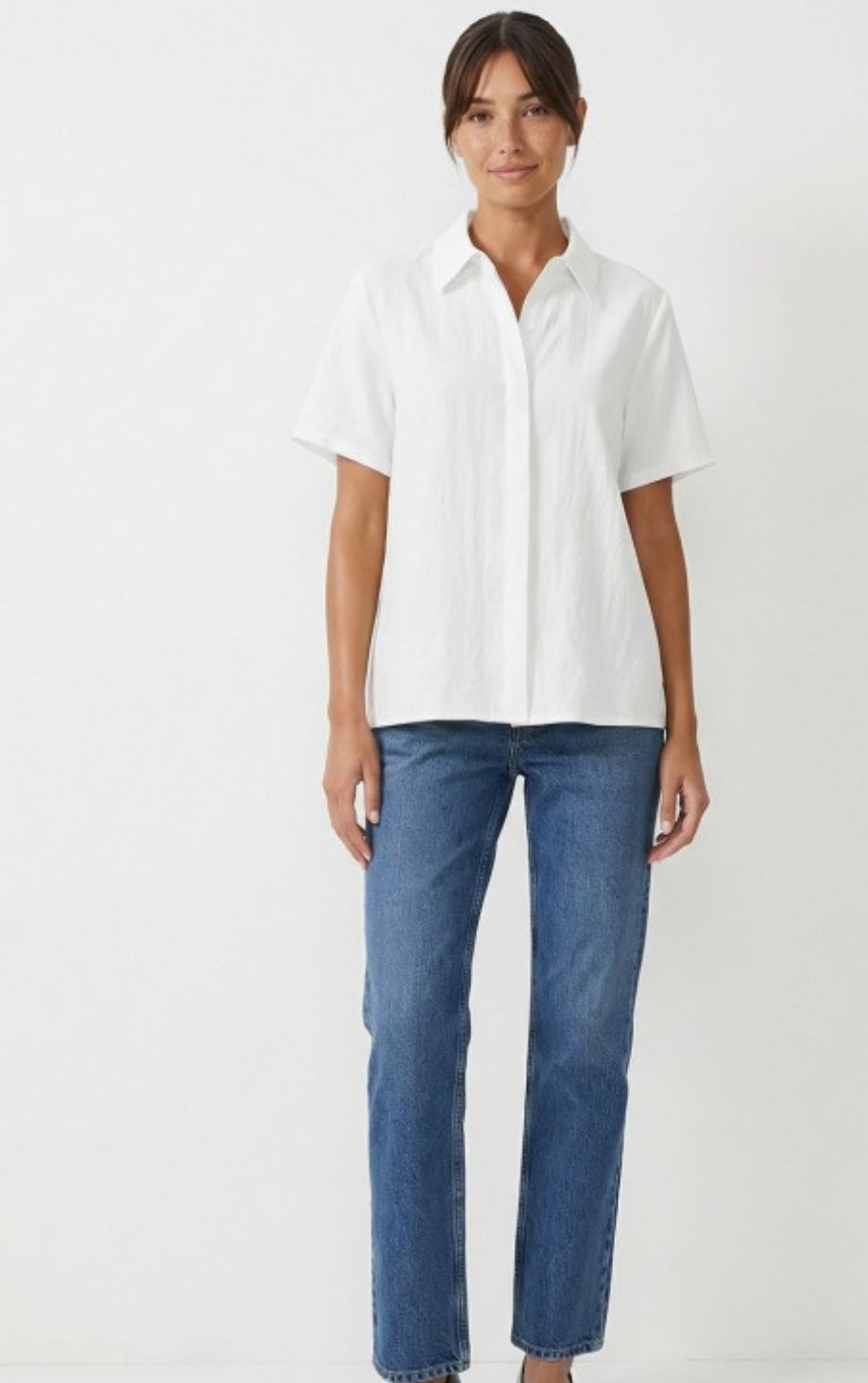 Person wearing a white shirt and blue jeans on a white background
