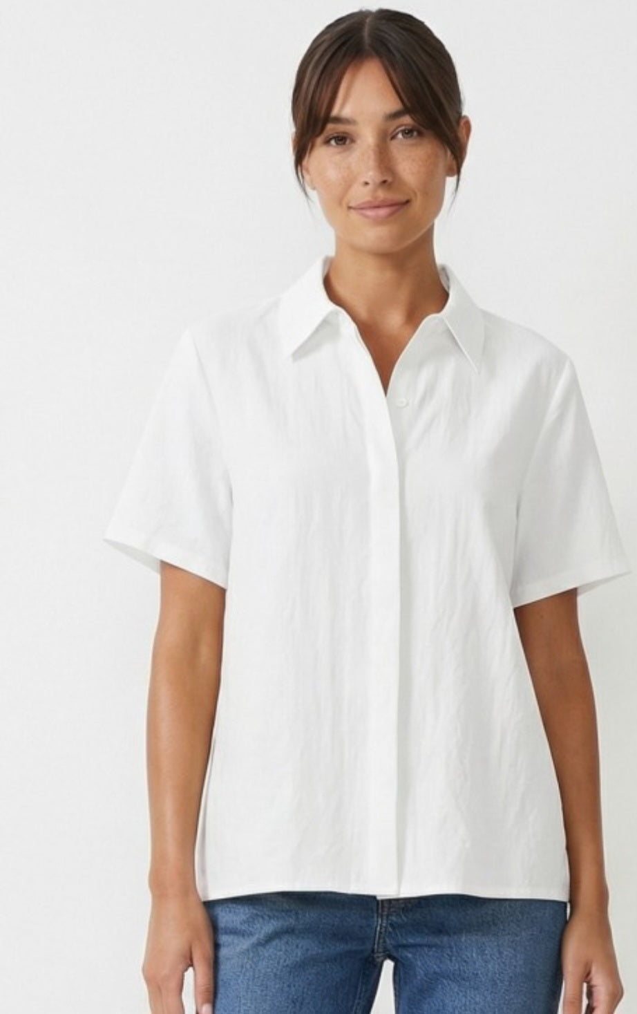 Woman wearing a white shirt and blue jeans on a white background