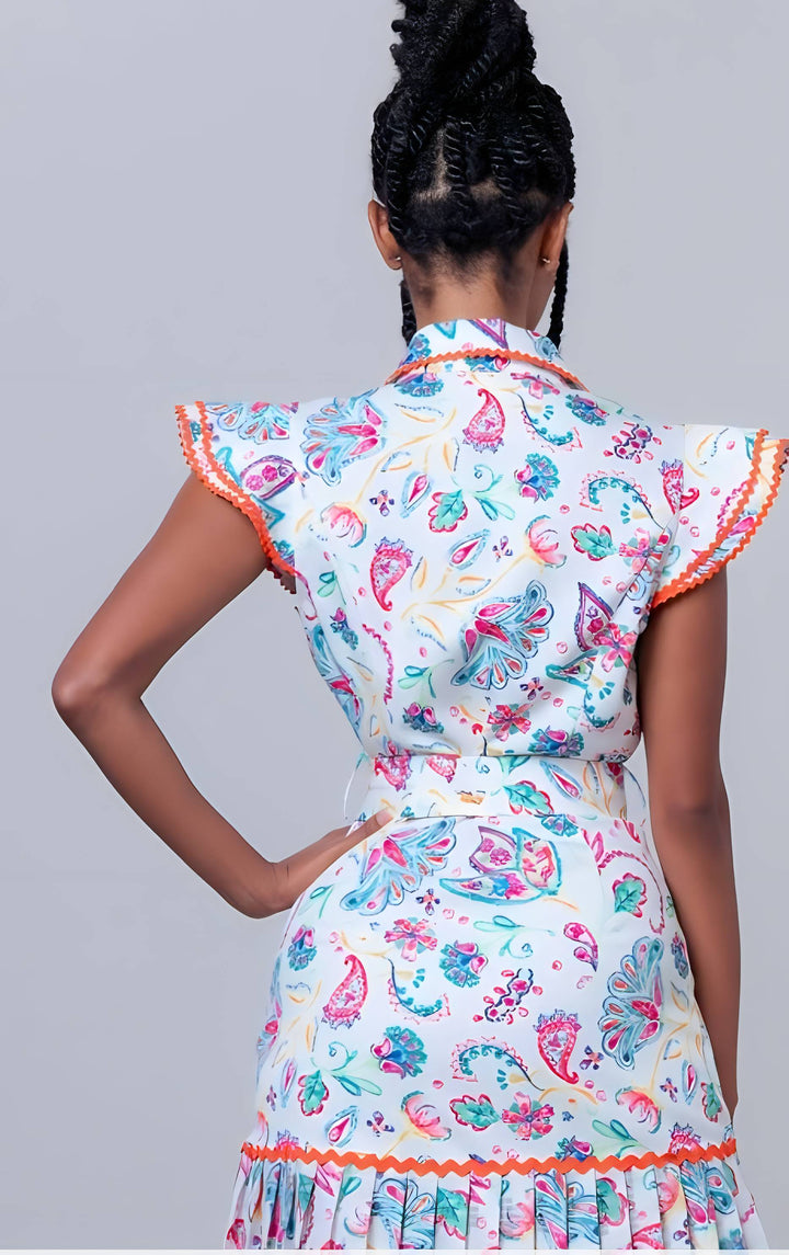 Person wearing a colorful floral dress with a plain background