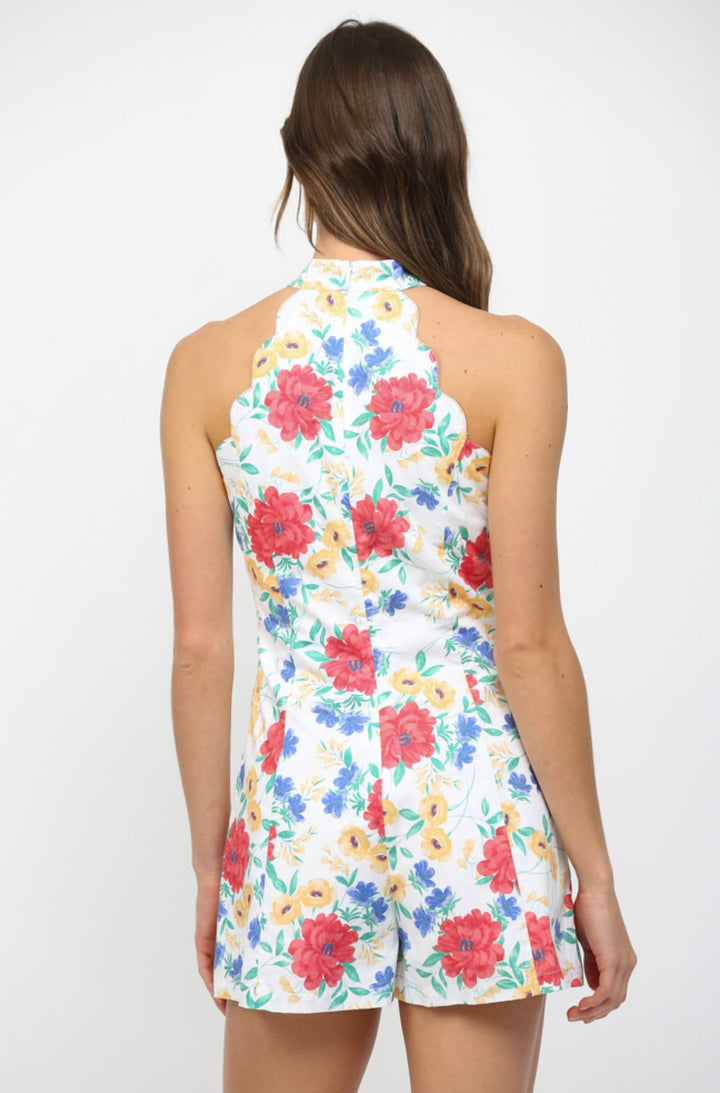 Woman wearing a floral romper on a white background