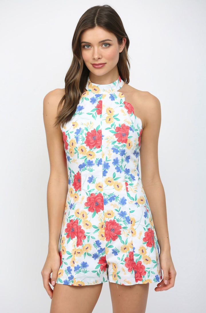 Woman wearing a colorful floral romper on a white background