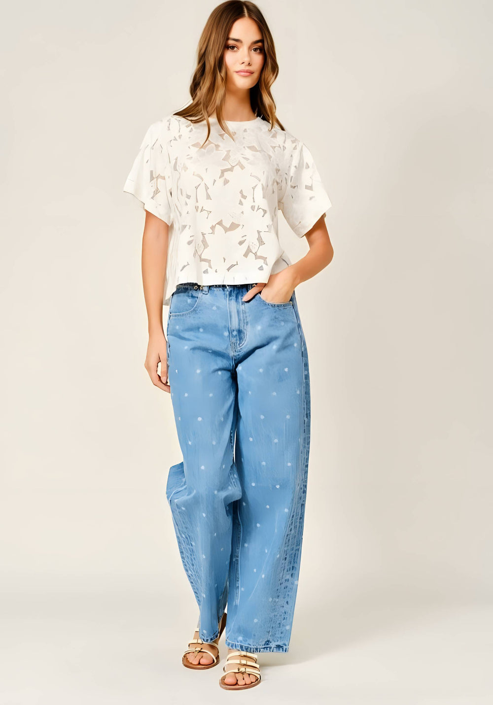 Woman wearing a white floral lace tee with jeans on a white background