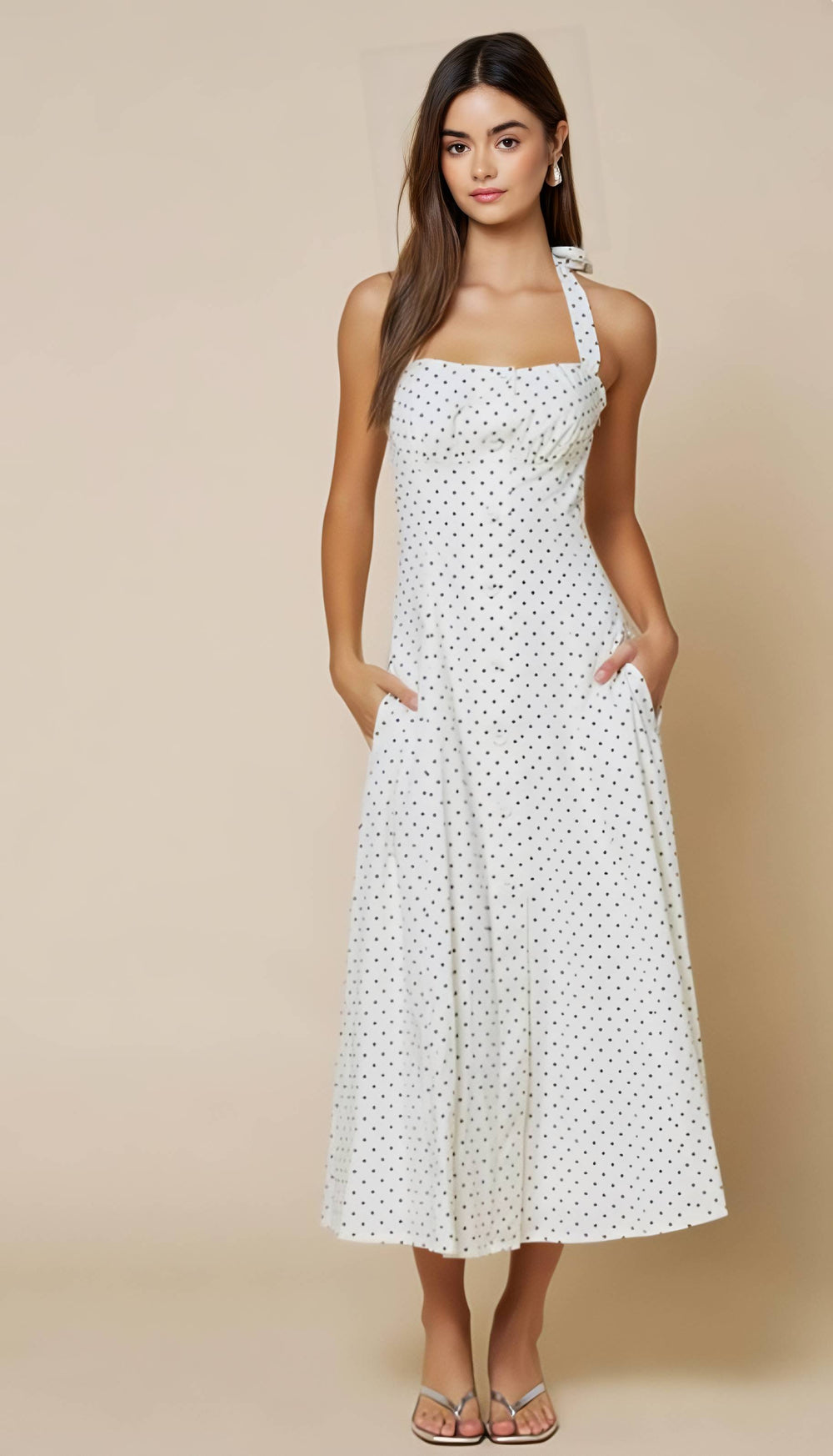 Woman wearing a white polka dot dress against a beige background