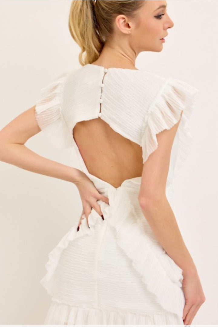 White dress with ruffled sleeves and open back on a plain background