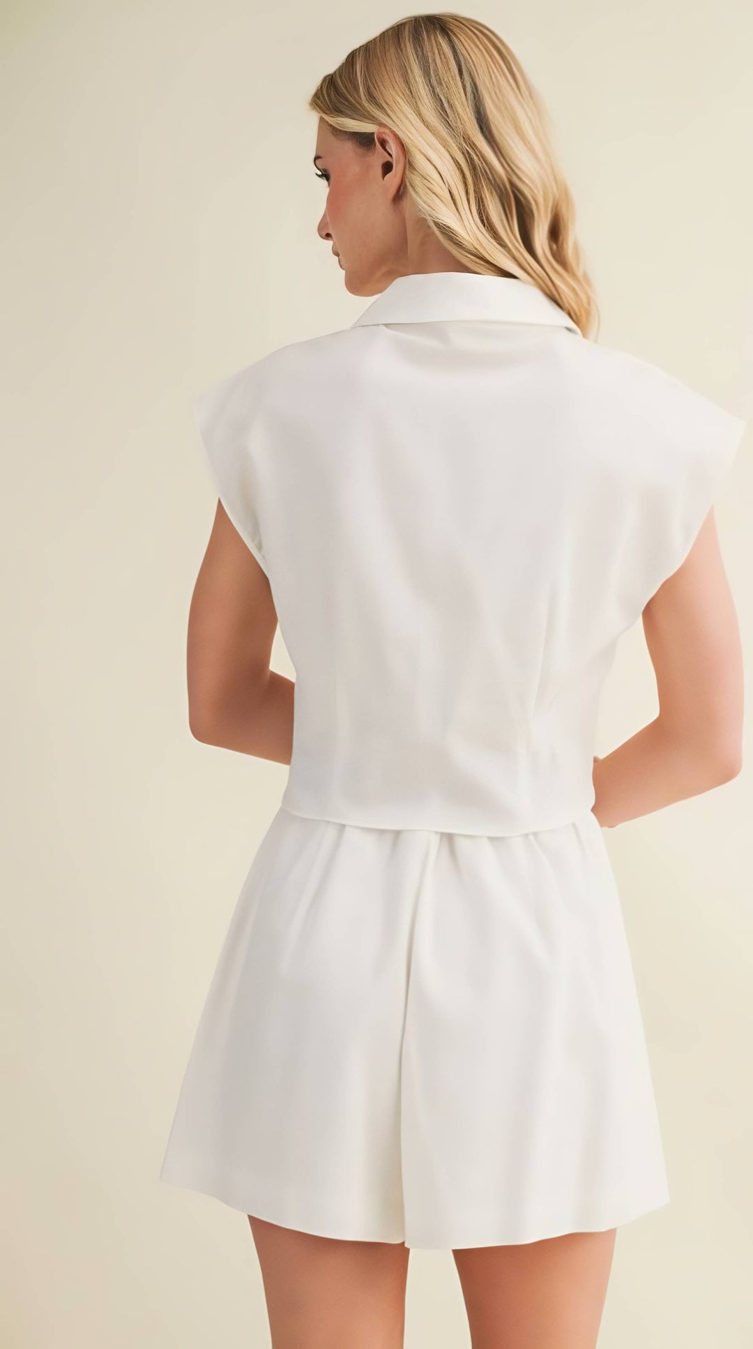 Woman wearing a white top against a beige background