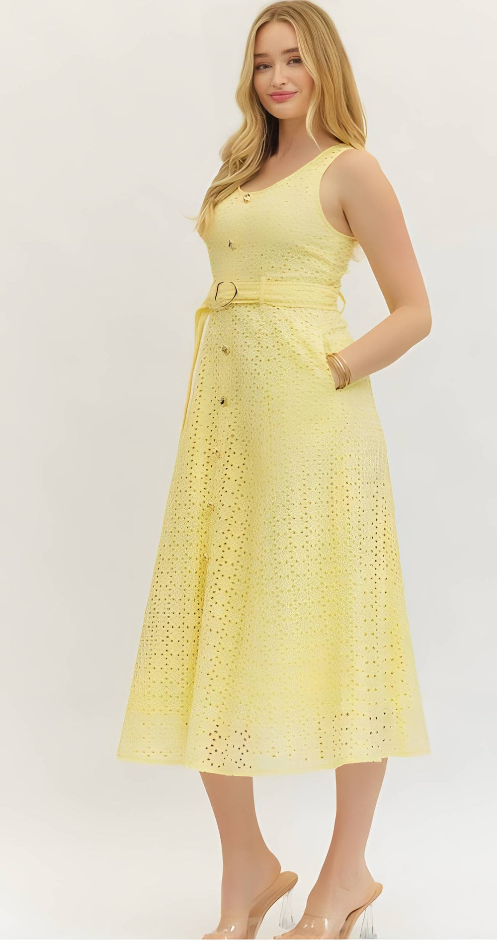 Woman wearing a yellow eyelet button belted dress on a white background