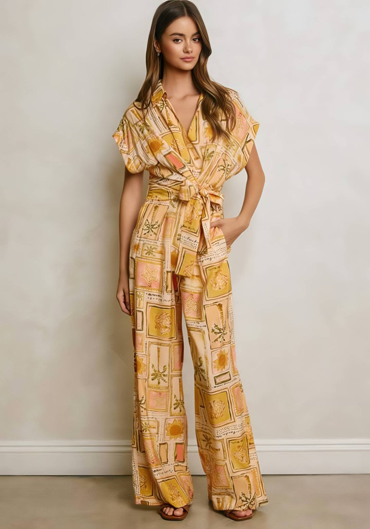 Woman wearing a patterned yellow jumpsuit against a plain background