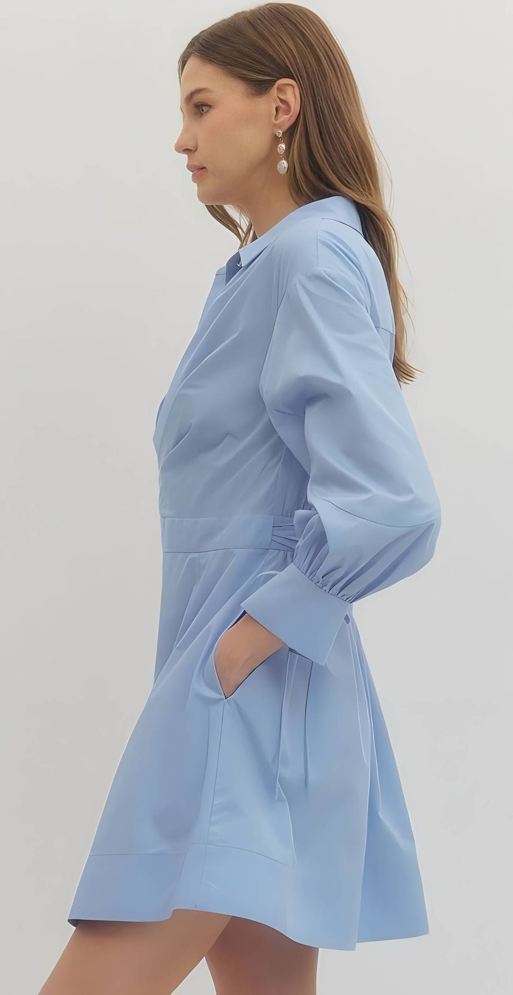 Woman wearing a light blue dress against a plain background